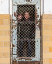 Senior man behind locked barred door in cell
