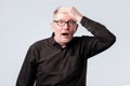 Senior man in black shirt putting his hand on the forehead remembering something Royalty Free Stock Photo