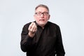 Senior man in black shirt showing italian gesture that means what do you want