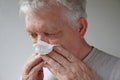 Senior man blows his nose with text space