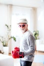 A senior man with boxing gloves having fun at home. Royalty Free Stock Photo