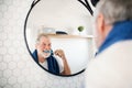 A senior man brushing teeth in bathroom indoors at home. Copy space. Royalty Free Stock Photo