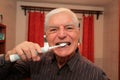 Senior man brushing teeth with electric toothbruch Royalty Free Stock Photo