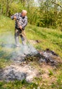 Senior man is burning dry branches in the garden Royalty Free Stock Photo