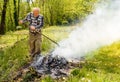 Senior man is burning dry branches in the garden Royalty Free Stock Photo