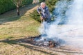 Senior man is burning dry branches Royalty Free Stock Photo