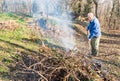 Senior man is burning dry branches. Royalty Free Stock Photo