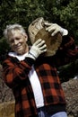 Senior man carrying firewood over his shoulders Royalty Free Stock Photo