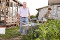 Senior man carrying garden tools in a wheelbarrow Royalty Free Stock Photo