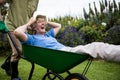 Senior man carrying his partner in wheelbarrow