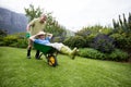 Senior man carrying his partner in wheelbarrow