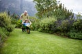 Senior man carrying his partner in wheelbarrow