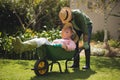 Senior man carrying smiling woman in wheel borrow Royalty Free Stock Photo