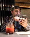 Senior man in casual clothes using mobile phone