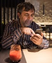Senior man in casual clothes using mobile phone