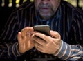 Senior man in casual clothes using mobile phone