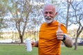 Senior man is catching a break after exercising. Refreshing with water.