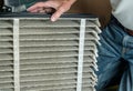 Senior man changing a dirty air filter in a HVAC Furnace Royalty Free Stock Photo