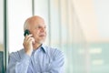 Senior man chatting on his smartphone in a high key portrait Royalty Free Stock Photo