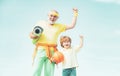 Senior man and child exercising on blue sky. Sports for kids. Sportsman grandfather and healthy kid with basketball ball Royalty Free Stock Photo