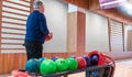 Senior man choosing bowling ball from rack at bowling alley, engaging in active recreation Royalty Free Stock Photo