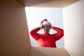 Senior man in christmas cap unpacking, opening carton box and looking inside. Royalty Free Stock Photo