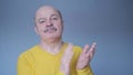 Senior man clapping and applauding with disbelief at his face. Studio shot