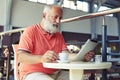 Senior man with coffee reading news Royalty Free Stock Photo
