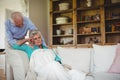 Senior man comforting senior woman in living room