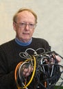 Senior man confused by tangled wires Royalty Free Stock Photo