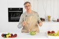 Senior Man Cooking Standing Smiling To Camera In Modern Kitchen Royalty Free Stock Photo