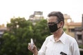 Senior man with corona preventive mask showing medicine ampul or vaccine standing on rooftop outdoor. Covid, Lock down and Home Royalty Free Stock Photo