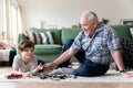 Senior man and cute boy playing with toys, having fun together Royalty Free Stock Photo