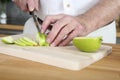 Senior man cutting apple in the kitchen. Conceptual image Royalty Free Stock Photo