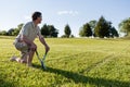 Senior man cutting grass with shears