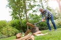 Senior man cutting logs with axe in yard focus on axe Royalty Free Stock Photo