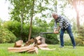 Senior man cutting logs with axe in yard focus on axe Royalty Free Stock Photo