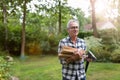 Senior man cutting logs with axe in yard focus on axe Royalty Free Stock Photo