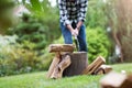 Senior man cutting logs with axe in yard focus on axe Royalty Free Stock Photo