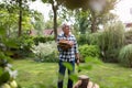 Senior man cutting logs with axe in yard focus on axe Royalty Free Stock Photo