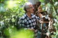 Senior man cutting logs with axe in yard focus on axe Royalty Free Stock Photo