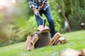 Senior man cutting logs with axe in yard focus on axe Royalty Free Stock Photo