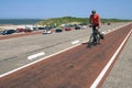 Senior man cycling on Dutch seawall Brouwersdam