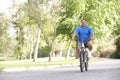 Senior Man Cycling In Park Royalty Free Stock Photo