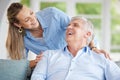 Senior man and daughter on sofa in their home, happy, smiling and bonding together. Elderly dad and woman laughing Royalty Free Stock Photo