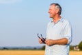 Senior man daydreaming outdoors in the countryside in a sunny da