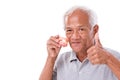 Senior man with denture, giving thumb up