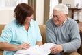 Senior Man In Discussion With Health Visitor At Ho