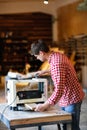 Senior man doing carpentry with edging plane on workbench Royalty Free Stock Photo