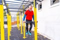 Senior man doing pull ups in an outdoor sports ground Royalty Free Stock Photo
